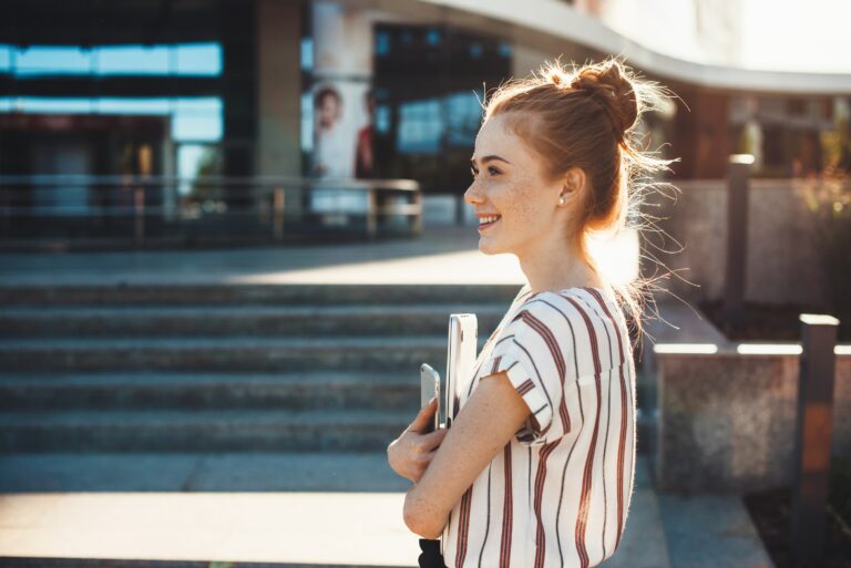 Cheerful Caucasian Girl Red Hair Walking On Campus Holding Books