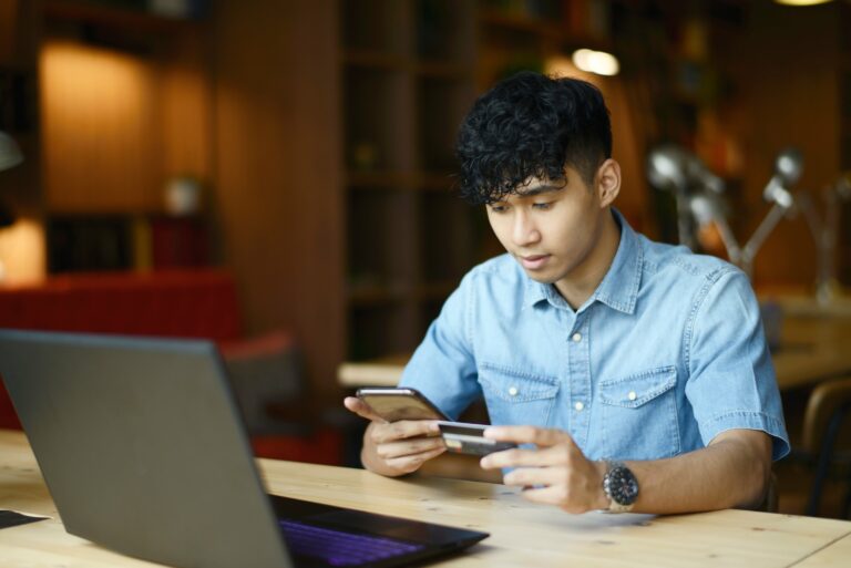 Young Man Holding Credit Card Phone