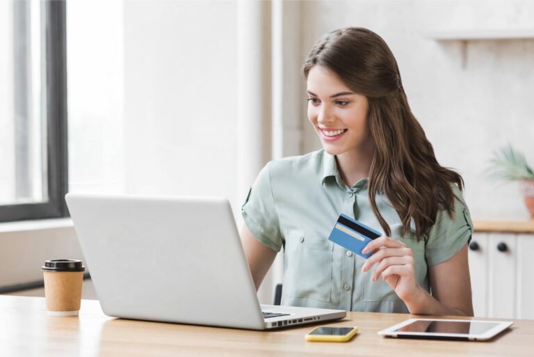 Young Woman Holding Credit Card Using Laptop